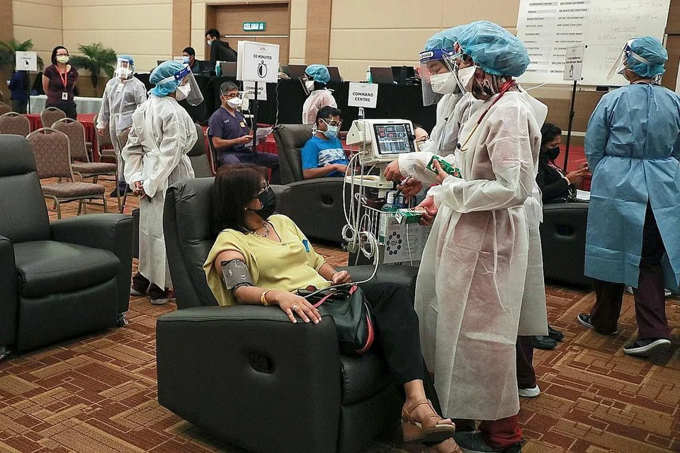 JALANI PEMERIKSAAN: Pekerja perubatan kelihatan sedang bercakap dengan seorang wanita yang sedang menjalani pemerhatian selepas menerima vaksin Covid-19 di Pusat Perubatan Sunway, di Subang Jaya, Selangor, pada 12 Mac lalu. - Foto REUTERS