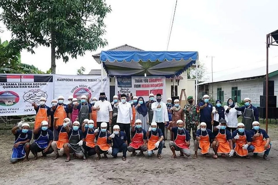 PENERIMA DAGING KORBAN: Para penduduk di sebuah kawasan di Medan ini menerima daging korban anjuran Nur Insan tahun lalu. - Foto NUR INSAN