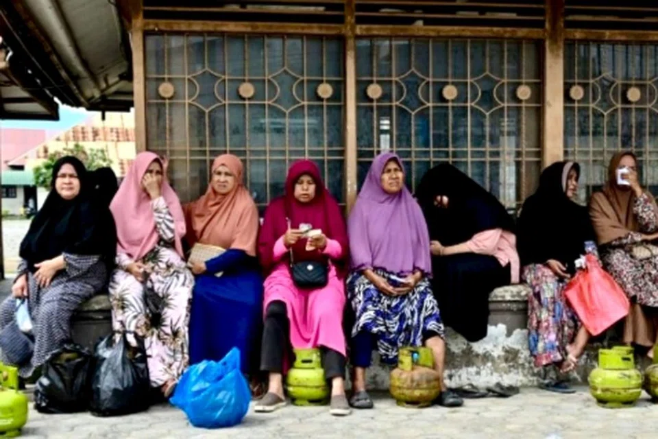 Para penduduk membawa balang gas seberat tiga kilogram yang kosong untuk menukarnya bagi membeli balang gas baru. 