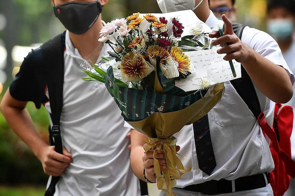 PERINGATI RAKAN SEKOLAH: Beberapa pelajar membawa bunga dan meletakkannya di ruang legar di sekolah untuk memperingati rakan mereka yang meninggal dunia dalam kejadian tersebut. - Foto BH oleh CHONG JUN LIANG 