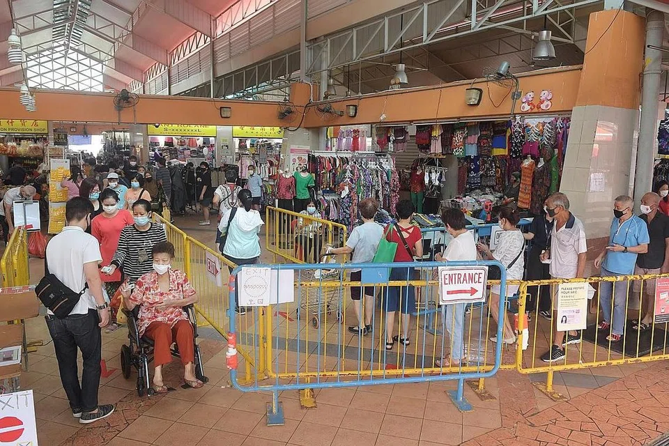 SEKATAN DILONGGARKAN: Pengunjung dilihat menunggu giliran untuk masuk Pasar Chong Pang (kiri) sekitar 10 pagi semalam. - Foto BH oleh ALPHONSUS CHERN