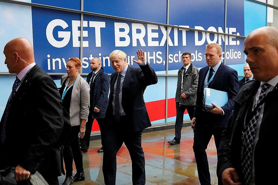 MASIH TERUSKAN USAHA: Encik Johnson (tengah, sedang melambai) dilihat di luar lokasi persidangan tahunan Parti Konservatif Britain di Manchester pada 29 September lalu. - Foto REUTERS