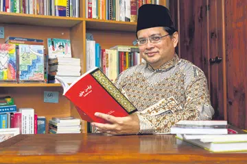 GUNA KAEDAH ESTETIK: Pengkaji tulisan Jawi Dr Hirman Mohamed Khamis menyarankan memancing minat anak muda terhadap bahasa warisan itu menggunakan kaedah estetik. Contohnya, kita boleh menyepadukan unsur warna dan lukisan persis rekaan grafik atau grafiti (contoh lukisan terakam pada bahagian kiri gambar utama, dalam rak-rak buku). - Foto BM oleh YONG LI XUAN