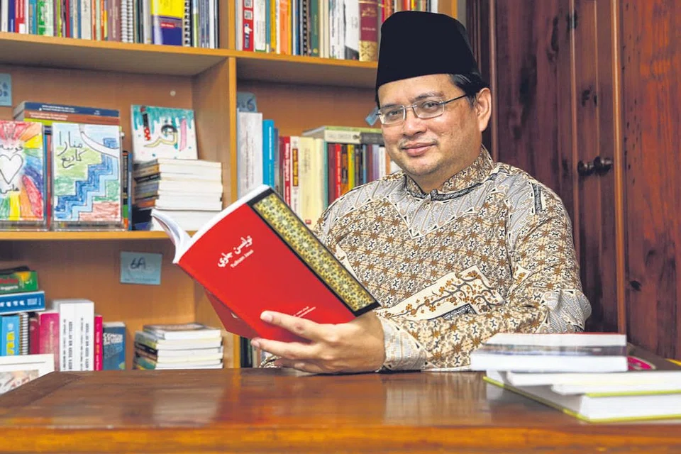 GUNA KAEDAH ESTETIK: Pengkaji tulisan Jawi Dr Hirman Mohamed Khamis menyarankan memancing minat anak muda terhadap bahasa warisan itu menggunakan kaedah estetik. Contohnya, kita boleh menyepadukan unsur warna dan lukisan persis rekaan grafik atau grafiti (contoh lukisan terakam pada bahagian kiri gambar utama, dalam rak-rak buku). - Foto BM oleh YONG LI XUAN