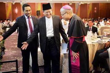 PENUH HORMAT: Moderator perbincangan, Profesor Abdullah Saeed (kiri) dan panelis, Mufti Dr Mohamed Fatris Bakaram (tengah), mempersilakan Ketua Biskop William Goh Seng Chye mengambil tempat. - Foto M.O. SALLEH