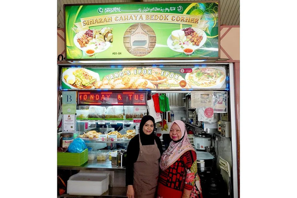 EPOK-EPOK: Selepas Cik Yang Hassan (kanan) buka gerainya semula pada 2015, beliau dapati ramai penjaja Melayu di Pusat Penjaja Bedok Corner menjual jamuan nasi seperti nasi padang dan nasi ambeng. Kini, anaknya Cik Rahimah Sinwan (kiri) akan teruskan resipi moyang mereka dalam membuat perniagaan epok-epok. - Foto BH oleh SYED MUHAMMAD FIRDAUS