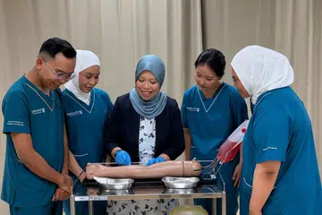 Cik Mis’Rohaiza Amin (tengah), Pengurus Kanan dan Ketua Program di Politeknik Ngee Ann (NP) bersama pelajarnya di Politeknik Ngee Ann.