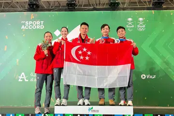BUAT KENANGAN: Pasukan wusyu Singapura (dari kiri) Le Yin Shuen, Vera Tan, jurulatih Zhang Feng, Jowen Lim dan Tay Yu Xuan bergambar semasa pertandingan Sukan Tempur Sedunia di Riyadh, Arab Saudi.
