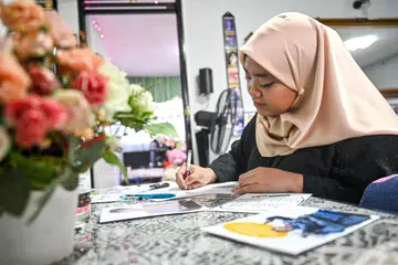 Cik Putri Mardhiyah Yazid membuat kad Raya menggunakan apa sahaja bahan yang ada di rumah. Kad Raya tersebut kemudian dipos kepada rakan dan kenalan, termasuk di seberang Tambak.