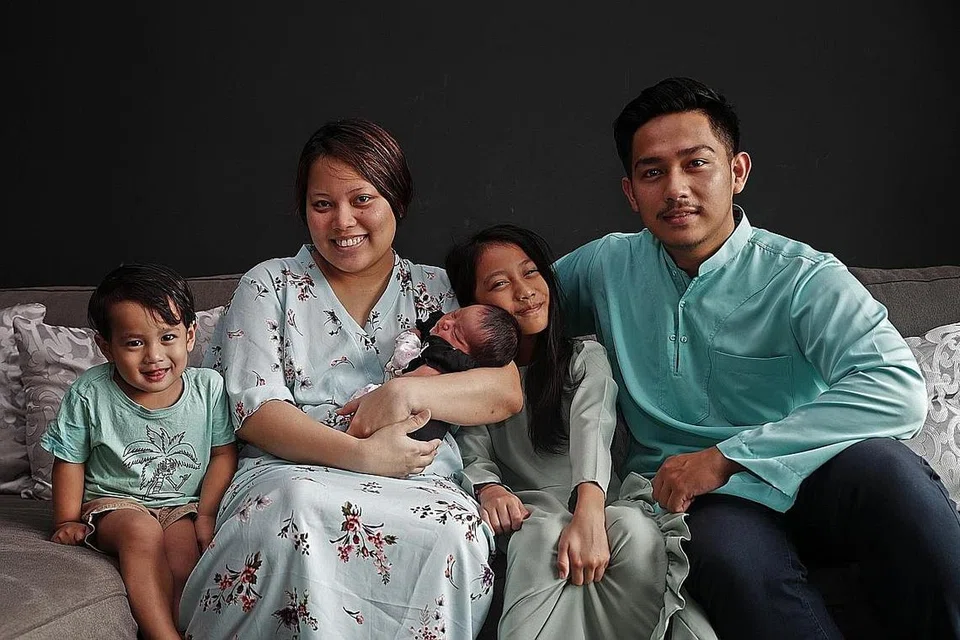 BAYI 'GRAB': Cik Nur Syazwani Muhd Rosdi melahirkan anak ketiganya, Mia Ariella Adhwin'a, dalam kenderaan Grab pada 7 Ogos lalu selepas mengalami pengecutan pelahiran yang amat kuat. Bersamanya, (dari kiri) anak kedua, Muhammad Syarul Adhwin; anak sulung, Marsha Adhwaa Aliani; dan suami, Encik Kamarulnizam Kiman. - Foto BH oleh GIN TAY