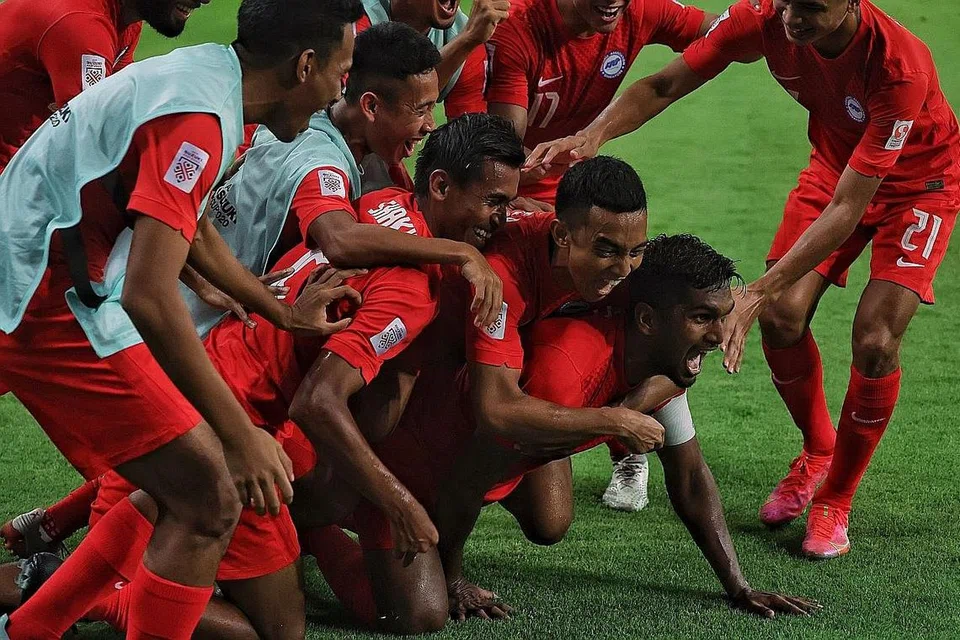 SEMANGAT BERPASUKAN TINGGI: Kapten Singa Hariss Harun dikerumuni rakan-rakannya semasa meraikan gol pertama mereka dalam kemenangan 2-1 ke atas Filipina di Stadium Negara malam kelmarin. - Foto BH oleh KEVIN LIM