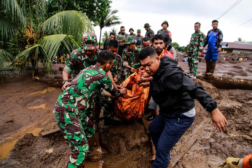 Pasukan penyelamat mengangkat beg mayat yang merupakan mangsa banjir di Kampung Rua, Ternate, di daerah Utara Maluku.