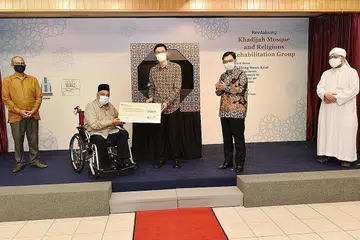 PROJEK PENINGKATAN: Ketua Eksekutif Muis, Encik Esa Masood (tengah), menyerahkan cek oleh Muis kepada pengerusi Masjid Khadijah, Ustaz Ali Mohamed, yang menerima bagi pihak masijd. Bersama mereka ialah Menteri Bertanggungjawab bagi Ehwal Masyarakat Islam, Encik Masagos Zulkilfli Masagos Mohamad (paling kiri), DPM Heng (dua dari kanan), dan pengerusi bersama RRG, Ustaz Mohd Hasbi Hassan (paling kanan). - Foto BH oleh DESMOND WEE