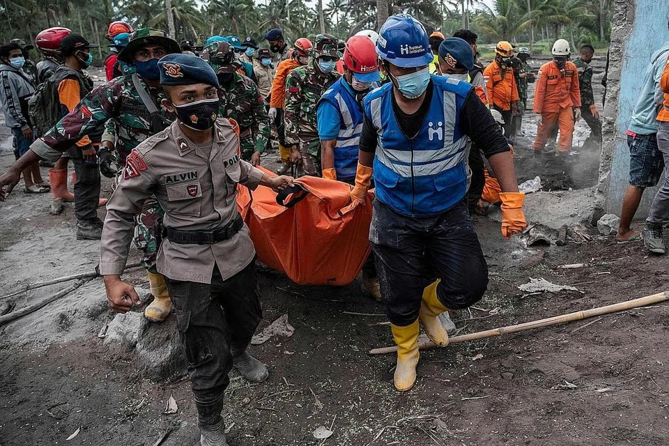 PROSES MENYELAMAT: Pasukan penyelamat membawa keluar mayat mangsa di kampung Sumber Wuluh di Lumajang pada 6 Disember 2021, selepas letusan gunung berapi Semeru mengorbankan sekurang-kurangnya 14 orang. - Foto AFP