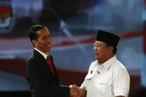 JABAT POLITIK: Dua calon presiden, Encik Joko Widodo (kiri) dan Encik Prabowo Subianto bersalaman sebelum acara debat kedua berlangsung malam tadi. - Foto