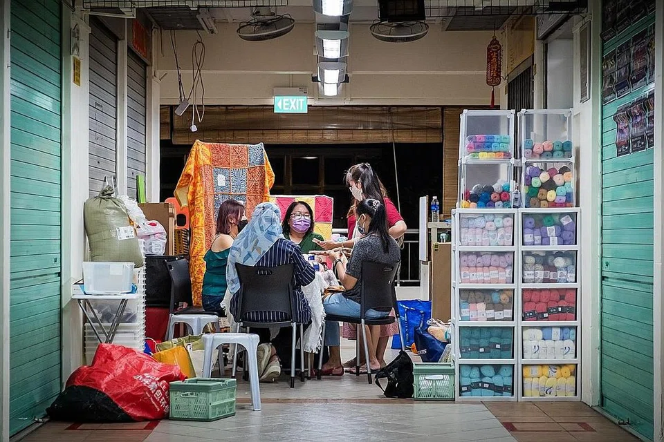 BERSEMBANG SAMBIL BERAMAL: Sekumpulan kawan mengait bersama di luar kedai di Pusat Makanan Golden Mile. Hasil kaitan mereka digunakan sebahagian selimut yang diberikan kepada warga emas Rumah Sunshine Welfare Action Mission. - Foto BH oleh GAVIN FOO
