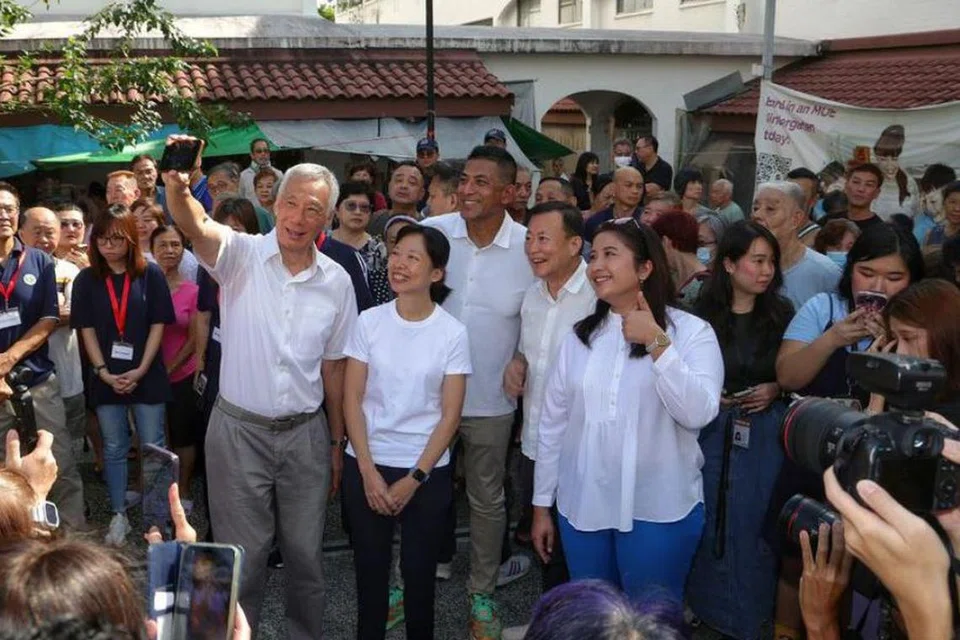 Menteri Kanan, Encik Lee Hsien Loong (kiri), bergambar bersama (dua dari kiri) Cik Jasmin Lau, Encik Darryl David, Encik Victor Lye, Cik Nadia Ahmad Samdin serta penduduk di Hougang Village pada 13 April.