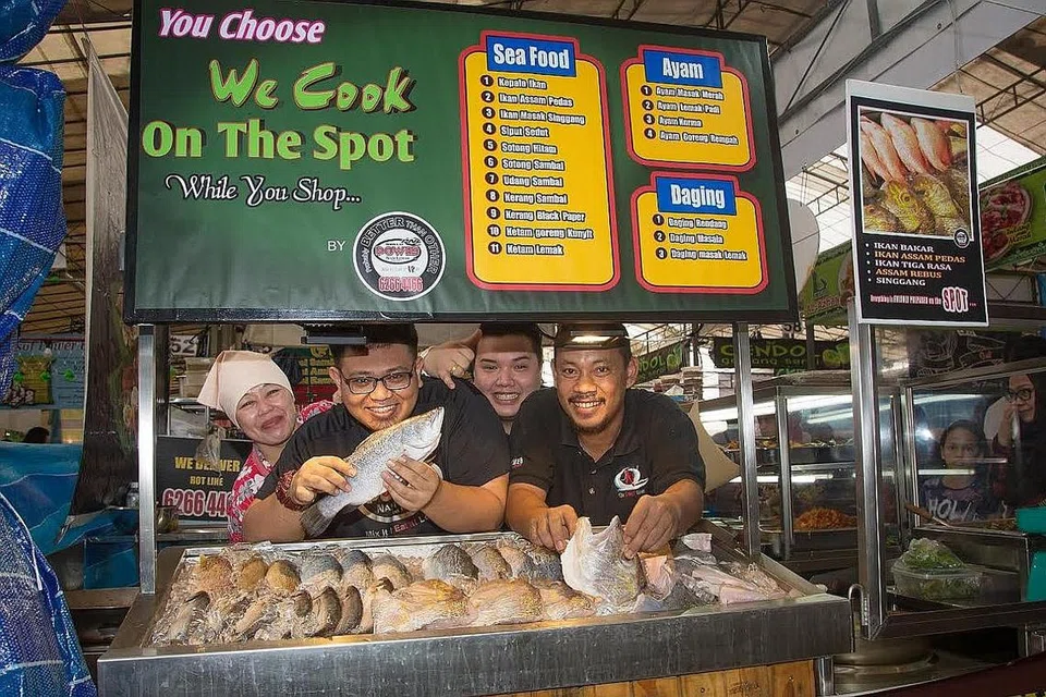 HIDANGAN SEGAR: Encik Muhammad Farhan Hamzah (berkaca mata) berkata perniagaan Boon Lay Power Nasi Lemak di Bazar Utara bertambah baik mungkin kerana tahun ini ia menjual hidangan ikan segar.