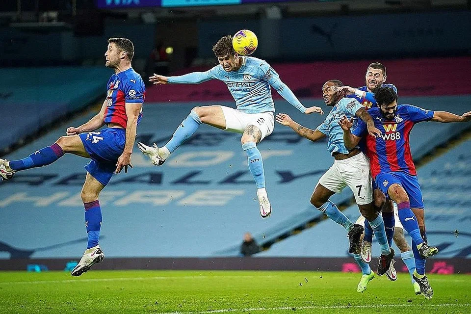 TANDUKAN HEBAT: John Stones (tengah) menanduk masuk bola ke gawang Crystal Palace untuk memberi kemenangan 4-0 kepada City, sekali gus membantu mereka melonjak ke tangga kedua liga. - Foto REUTERS