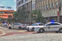 KEJADIAN TEMBAKAN: Foto menunjukkan kenderaan polis mengepung jalan ke kawasan Jacksonville Landing di mana beberapa orang terkorban dan 11 yang lain cedera, selepas seorang peserta pertandingan melepaskan tembakan sebelum menembak diri sendiri. - Foto AFP
