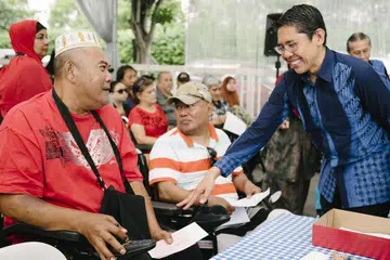 TIDAK DILUPAKAN: Dr Mohamad Maliki Osman (kanan) sedang berinteraksi bersama beberapa penerima bantuan kewangan dalam satu majlis anjuran Darul Arqam baru-baru ini. - Foto BH oleh ALVIN HO