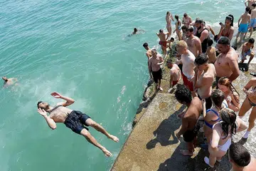 PANAS TERIK: Seorang lelaki terjun ke laut sewaktu berlaku gelombang haba di Brighton, Britain, pada 19 Julai lalu.