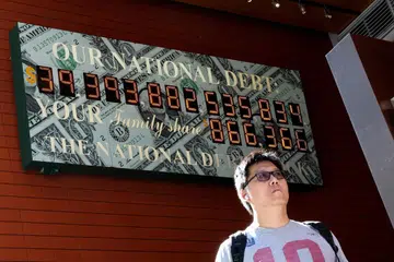 Seorang lelaki berjalan melintasi Jam Hutang Negara di New York City, Amerika Syarikat, pada 19 Ogos 2026. Hutang negara Amerika Syarikat melepasi paras AS$40 trilion ($51.3 trilion) buat kali pertama, sedang Washington dijangka meminjam lebih AS$2 trilion tahun ini bagi membiayai perbelanjaannya, termasuk kos perang dengan Iran dan pemotongan cukai.
