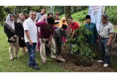 'MENYEMAI' IKATAN ERAT KELUARGA: Encik Hussain Lamat, 'pak lurah' lama keluarga (bersongkok, empat dari kanan) mengetuai acara menanam pokok perpaduan durian belanda dengan dibantu Dr Faishal (tiga dari kanan) dan Encik Mohd Amin Ab Latip, Pengerusi Masjid Petempatan Melayu Sembawang (baris depan, dua dari kiri). Turut hadir ialah anggota keluarga lain, termasuk 'pak lurah' baru, Encik Abdolah (dua dari kanan), dan Encik Suhaimi Salleh (baris depan, kiri), generasi ketiga keluarga itu. - Foto ihsan ABDOLAH LAMAT
