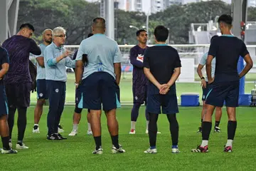 Jurulatih Singapura, Tsutomu Ogura (bercermin mata), mengatur taktik dengan pemain-pemainnya dalam sesi latihan di Hab Bola Sepak Kallang pada 23 Disember. 
