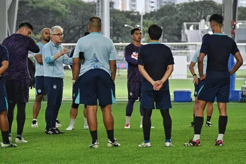 Jurulatih Singapura, Tsutomu Ogura (bercermin mata), mengatur taktik dengan pemain-pemainnya dalam sesi latihan di Hab Bola Sepak Kallang pada 23 Disember. 