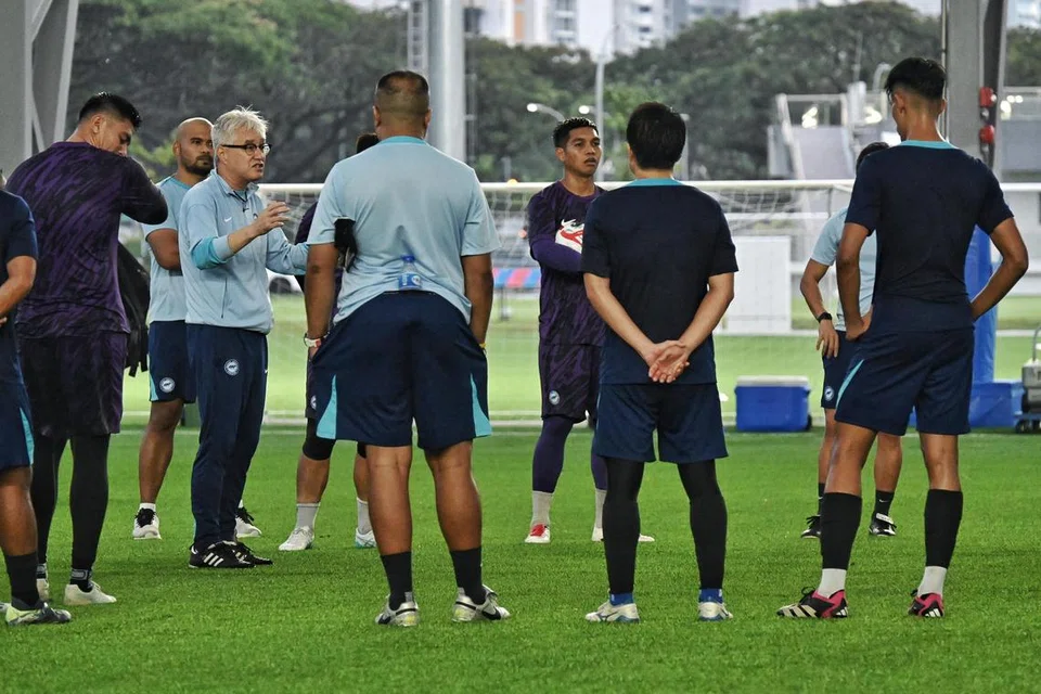 Jurulatih Singapura, Tsutomu Ogura (bercermin mata), mengatur taktik dengan pemain-pemainnya dalam sesi latihan di Hab Bola Sepak Kallang pada 23 Disember. 