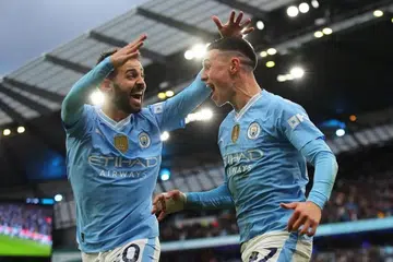 Phil Foden (kanan) dari Manchester City meraikan bersama rakan sepasukan Bernado Silva selepas menjaringkan gol kedua pasukannya menentang Manchester United pada 3 Mac. 