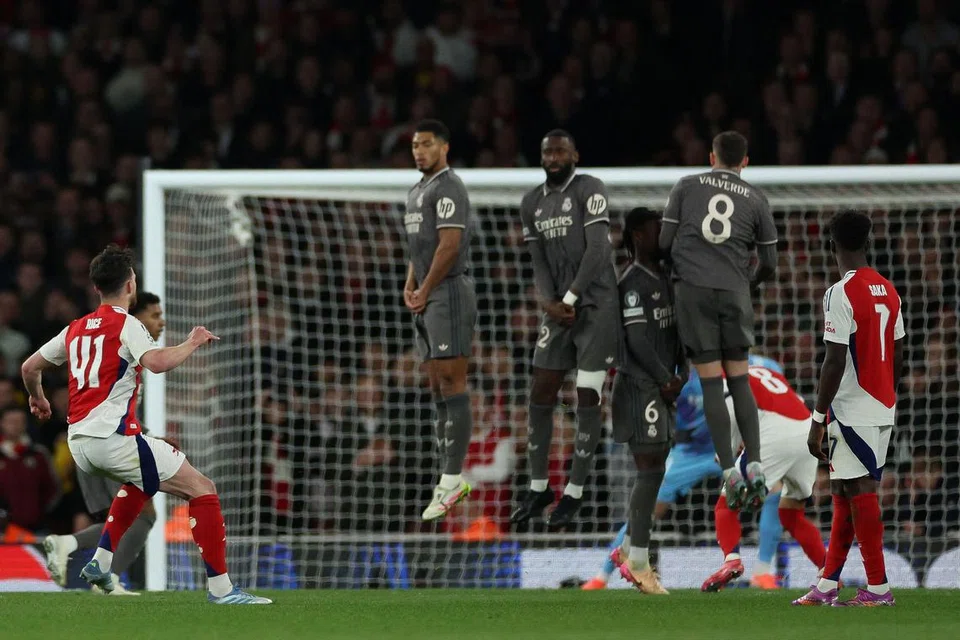 Pemain tengah Declan Rice (kiri) menjaringkan gol pertama Arsenal daripada tendangan percuma hebat yang melepasi benteng pertahanan dan penjaga gawang Real Madrid, dalam perlawanan pertama suku akhir  Liga Juara-Juara mereka. 