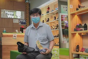 KASUT DIABETIK: Pengarah dan pengasas syarikat Happy Walker, Encik Teo Shu Tong, sedang memegang kasut diabetik, sesuai untuk mereka yang mengalami masalah kencing manis dan kasut tumit tinggi wanita, sesuai untuk sambutan Lebaran. Kasut Happy Walker disertakan dengan lapik dalam kasut yang dihasilkan bersesuaian dengan tapak kaki anda. - Foto HAPPY WALKER