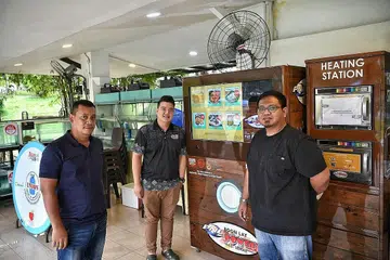 MESIN LAYAN DIRI DIPERLUAS: (Dari kiri) Penyelia Encik Zulkifli Talib; penolong pengurus, Encik Firdarif Rosli; dan pengurus Encik Farhan Hamzah; daripada Boon Lay Power Nasi Lemak di sebuah mesin layan diri syarikat itu yang terletak di Kolam Pancing Pasir Ris. Syarikat itu kini mempunyai sekitar 15 mesin di serata Singapura. - Foto BH oleh ARIFFIN JAMAR