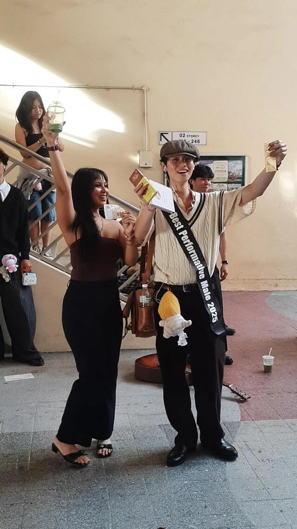 Pemenang pertandingan ‘lelaki performatif terbaik’, Encik Marvin (kanan) menerima habuan $100 daripada penganjur pertandingan tersebut, Cik Tatiana Rosli.