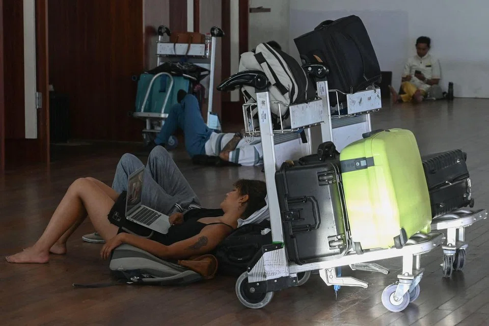 
Penumpang yang penerbangannya dibatalkan menunggu di Lapangan Terbang Antarabangsa Ngurah Rai selepas letusan Gunung Lewotobi Laki-Laki yang terletak berhampiran, meletuskan abu yang menjulang tinggi ke udara, di Tuban, berhampiran Denpasar, di pulau peranginan Bali, Indonesia pada 13 November 2024.