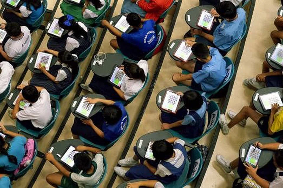 MEMBURU KOSA KATA SESUAI: Sebahagian daripada lebih 250 pelajar sekolah rendah dan menengah yang mengambil bahagian dalam peraduan sulung permainan 'App Pintar Kata' anjuran Pusat Bahasa Melayu Singapura (MLCS) semalam, yang menguji penguasaan kosa kata bahasa Melayu pelajar itu melalui aplikasi ICT baru yang dibangunkan MLCS. - Foto TUKIMAN WARJI