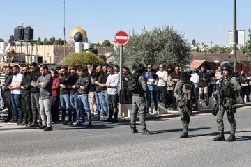 DIKAWAL KETAT: Warga Palestin melaksanakan solat Jumaat di kejiranan Ras al-Amud di Baitulmakdis sambil dikelilingi pasukan keselamatan Israel susulan genjatan senjata antara Israel dan Hamas di Carikan Gaza pada 24 November 2023.
