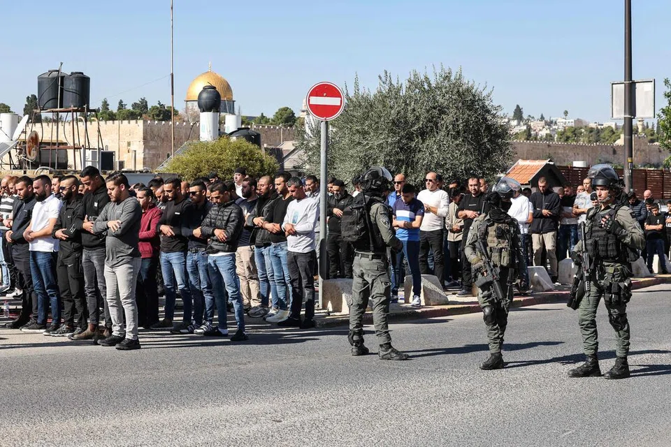 DIKAWAL KETAT: Warga Palestin melaksanakan solat Jumaat di kejiranan Ras al-Amud di Baitulmakdis sambil dikelilingi pasukan keselamatan Israel susulan genjatan senjata antara Israel dan Hamas di Carikan Gaza pada 24 November 2023.
