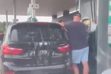 PEMANDU S’PURA TIDAK HIRAUKAN TEGURAN: Pemandu kereta BMW berdaftar S’pura ini terus mengisi minyak dengan ROM95 berwarna kuning, walaupun dimarahi orang M’sia
