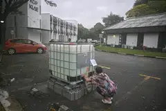 Seorang penyewa dan pemilik studio yoga di Phoenix Park, Cik Lim, sedang mengambil air daripada tangki air yang disediakan PUB untuk kegunaan di tandas. 