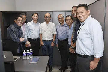 MENDEKATI MASYARAKAT: Dr Maliki (paling kiri); Dr Faishal (tiga dari kiri); Encik Masagos (empat dari kanan); Editor BH/BM Encik Saat A. Rahman (tiga dari kanan); Pengurus Besar WGS, Encik Mulyadi Ahmad (dua dari kanan) bersama kakitangan BH/BM (dari kanan) Encik Chairul Fahmy Hussaini, Encik Mohd Nizam Ismail dan Encik Adli Yashir Kuchit di ruangan Berita Harian di KURNIA@WGS.