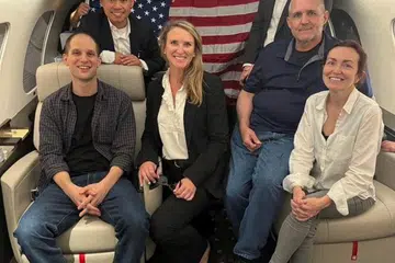 Wartawan Amerika Syarikat, Encik Evan Gershkovich (paling kiri); bekas anggota marin, Encik Paul Whelan (dua dari kanan), adalah sebahagian daripada pertukaran berbilang tahanan, bergambar di dalam pesawat selepas mereka dibebaskan. Gambar diedarkan pemerintah Amerika yang diperoleh pada 1 Ogos 2024. 