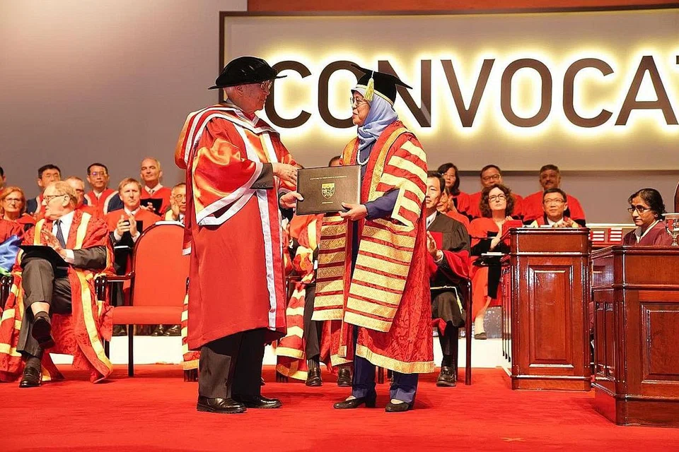 DIBERI IJAZAH KEDOKTORAN KEHORMAT: Mantan Presiden Singapura Dr Tony Tan Keng Yam (kiri) menerima ijazah kehormat daripada Presiden Singapura serta Canselor NTU, Puan Halimah Yacob, semasa majlis Konvokesyen NTU 2018 semalam. - Foto NTU