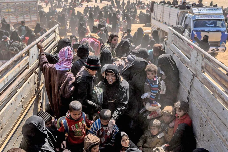 TIDAK TERJADI SEBAGAIMANA DIKATA: Wanita yang membawa bayi dan lelaki yang cedera bertongkat dipindahkan keluar dari kampung puak pelampau terakhir di Baghouz di timur Syria Mac lalu selepas tentera yang disokong Amerika Syarikat berjaya menguasai kawasan itu daripada kumpulan radikal. - Foto AFP