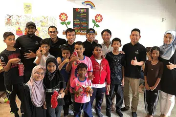 PROJEK KEMANUSIAAN: Sesi bergambar bersama anak-anak pelajar Rohingya di Kota Tinggi Refugees Learning Centre sempena acara Project Humanitarian Hearts to Hands (H2H), dimana belia Masjid Darul Makmur membimbing perbualan dalam bahasa Inggeris. Ustaz Muhd Fazli (gambar atas, tiga dari kanan). Turut serta dalam acara ini ialah Anggota Parlimen Nee Soon, Encik Louis Ng (lima dari kanan juga dalam gambar atas). - Foto MASJID DARUL MAKMUR
