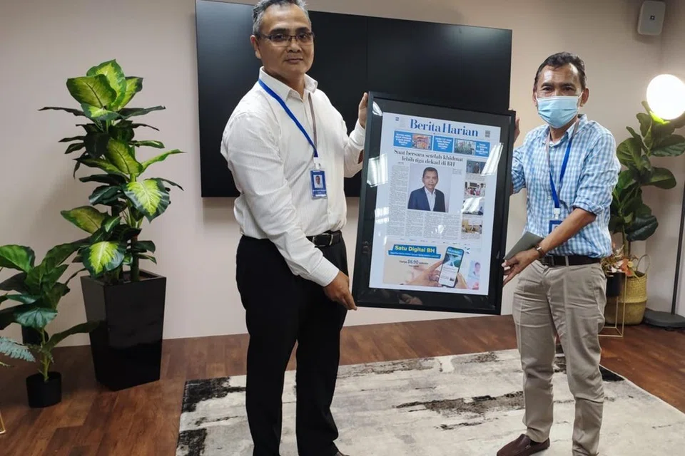 PERUBAHAN PUCUK PIMPINAN: Encik Nazry Mokhtar (kiri) menyampaikan cenderahati sebagai penghargaan kepada Encik Saat A. Rahman dalam satu majlis perjumpaan di bilik berita. 