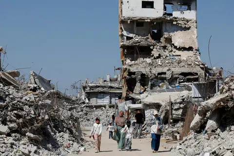 Penduduk Palestin berjalan di celah runtuhan bangunan kediaman yang musnah akibat peperangan di Kem Pelarian Jabalia, utara Gaza, pada 5 Ogos 2026. Ketika sebahagian besar penduduk masih tinggal dalam keadaan serba daif, Lembaga Keamanan yang diterajui Amerika Syarikat mula memuktamadkan kontrak pembinaan pertama di Gaza bagi menyediakan kemudahan untuk Pasukan Penstabilan Antarabangsa (ISF), sebagai sebahagian daripada pelan pembinaan semula dan pentadbiran pascakonflik di wilayah itu.