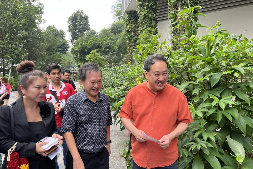 TEMUI PENGUNDI: Bakal calon presiden, Encik Tan Kin Lian (tengah) bersama penyokongnya, Encik Lim Tean, semasa lawatannya ke Kampung Admiralty pada Sabtu.